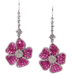 May include: A pair of dangle earrings featuring pink sapphire flower designs with diamond accents. The earrings are made of white gold and have a delicate, feminine look.