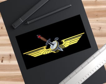 May include: A graphic illustration featuring a dagger with a brown handle and red pommel, piercing a round pocket watch. The watch is centered between two large, stylized yellow wings. A metal ruler shows a length of approximately 8 inches.