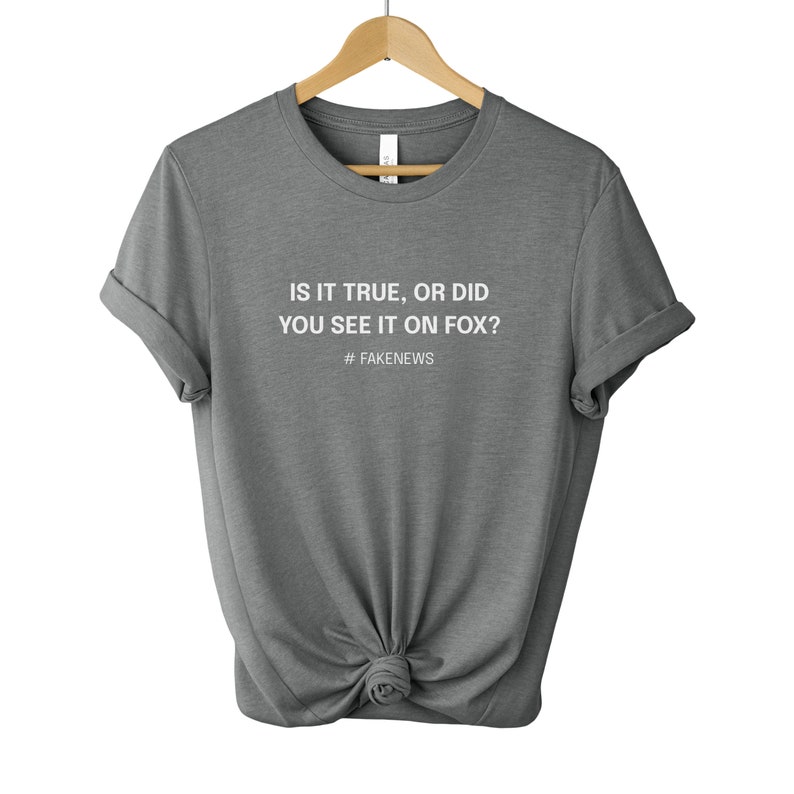 May include: A heather grey t-shirt with the text "Is it true, or did you see it on Fox? #fakenews" printed in white.