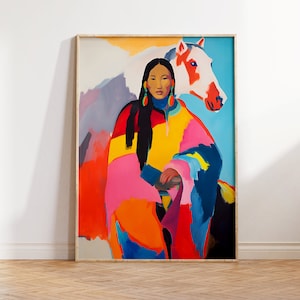 May include: A framed art print depicting a woman and a white horse with red markings. The woman is wearing a colourful garment with pink, orange, yellow, and blue hues. The background has a light blue and purple colour scheme.