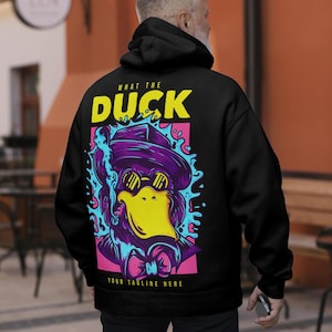 May include: A black hoodie featuring a graphic on the back with the text "WHAT THE DUCK" and "YOUR TAGLINE HERE". The design depicts a purple duck wearing a hat, sunglasses, and a bowtie, smoking a cigar, surrounded by blue splashes on a pink background.