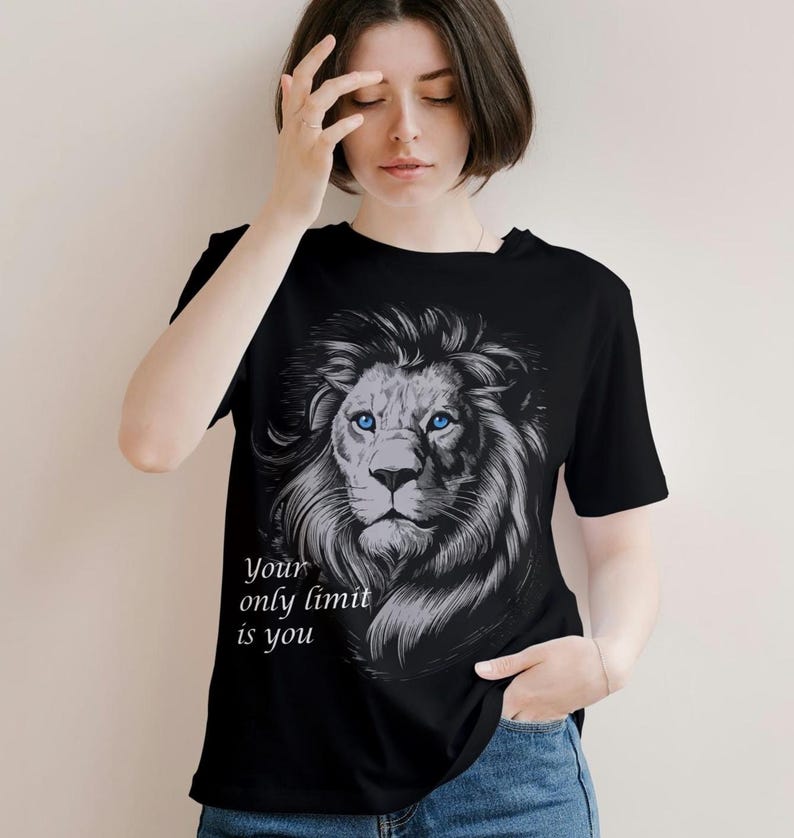 Puede incluir: Camiseta negra con un gr&aacute;fico de la cabeza de un le&oacute;n con ojos azules. El texto "Your only limit is you" est&aacute; impreso debajo del le&oacute;n.