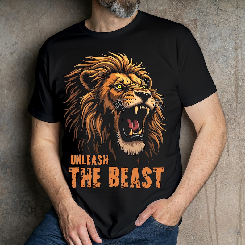 Puede incluir: Camiseta negra con un gr&aacute;fico de un le&oacute;n rugiente y el texto "UNLEASH THE BEAST" en naranja.