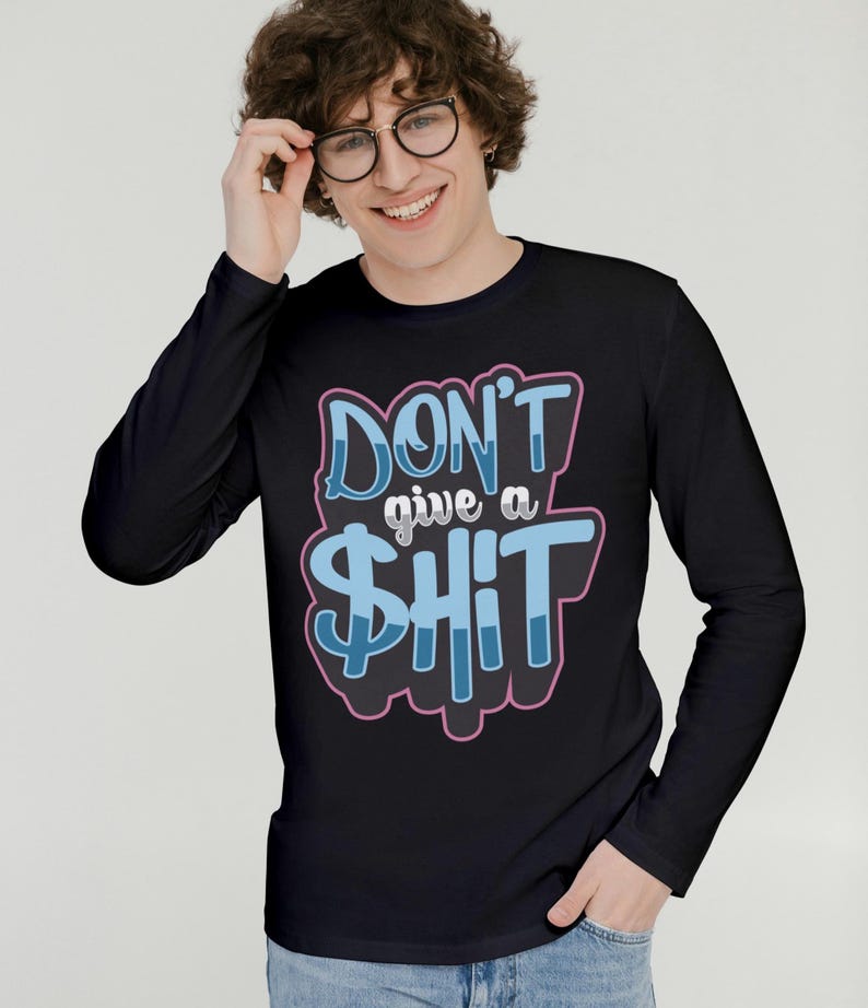 May include: Black long-sleeve shirt with the text "DON'T give a $HIT" in blue and pink lettering. The shirt has a crew neck and is made of a soft material. The graphic design is centered on the front of the shirt.