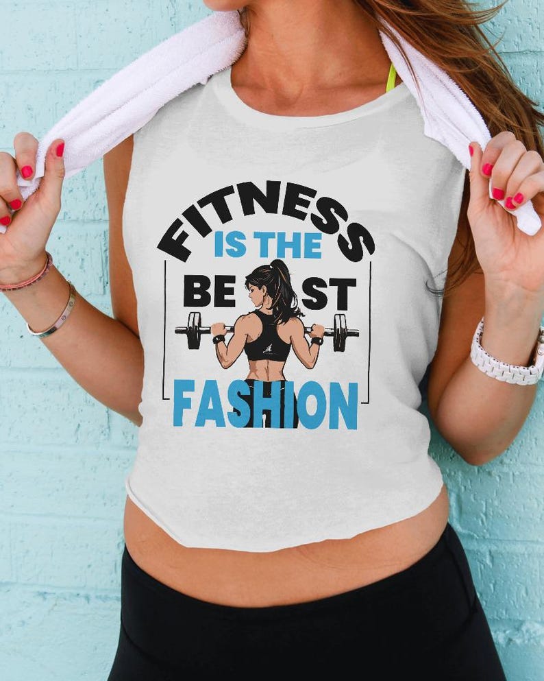 May include: White tank top with the text "FITNESS IS THE BEST FASHION" in black and blue. The graphic features a woman lifting weights. The woman is wearing a black sports bra. The person is wearing black athletic pants.
