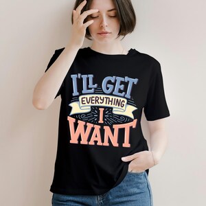 May include: Black t-shirt with the text "I'll Get Everything I Want" in blue, yellow, and coral lettering. The shirt has a crew neck and short sleeves. The design is centered on the front of the shirt.