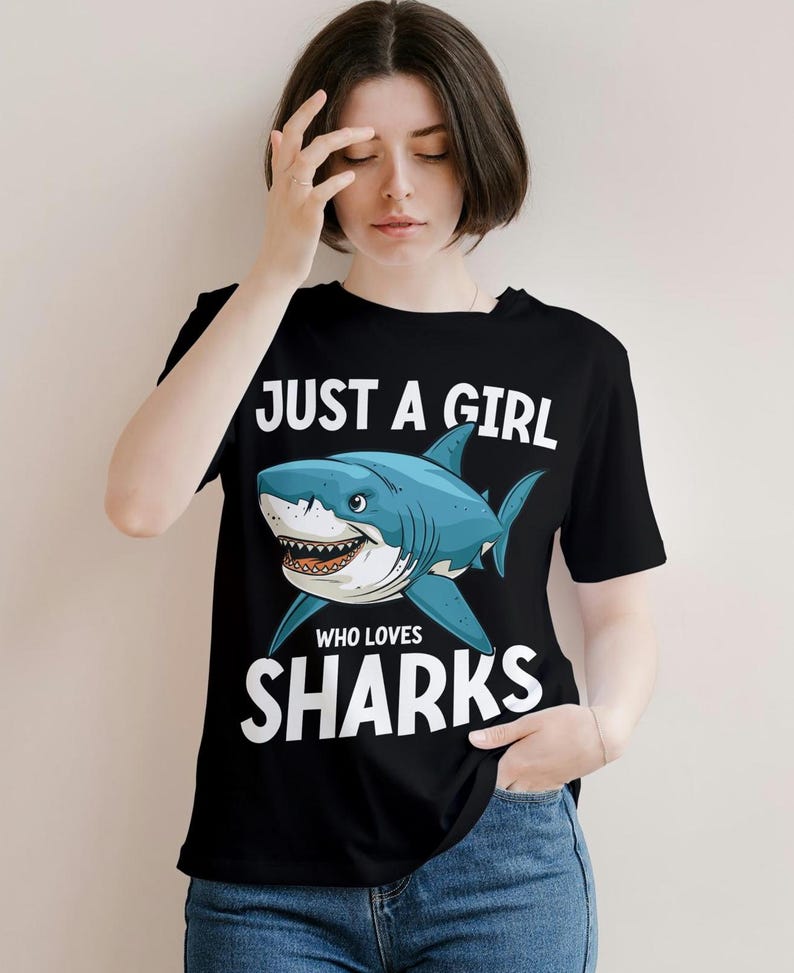 May include: Black t-shirt with a white graphic of a shark and the text "Just a girl who loves sharks".