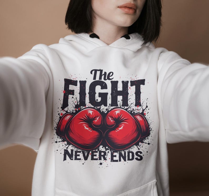Peut inclure: Sweat-shirt blanc avec un imprim&eacute; graphique de gants de boxe et le texte "The Fight Never Ends".