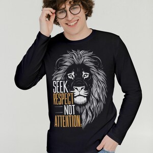 Puede incluir: Camiseta negra de manga larga con un gr&aacute;fico de una cabeza de le&oacute;n y el texto "SEEK RESPECT NOT ATTENTION."