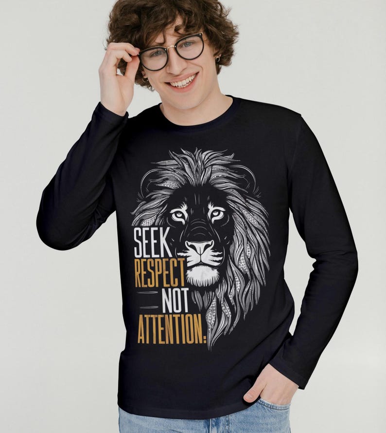 Puede incluir: Camiseta negra de manga larga con un gr&aacute;fico de una cabeza de le&oacute;n y el texto "SEEK RESPECT NOT ATTENTION."