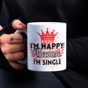 May include: White ceramic mug with a red crown and black text that reads "I'm Happy Because I'm Single".