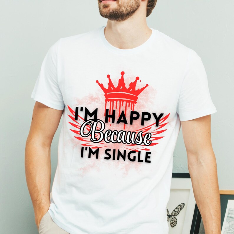 May include: White t-shirt with a red crown and wings, and the text "I'm Happy Because I'm Single".