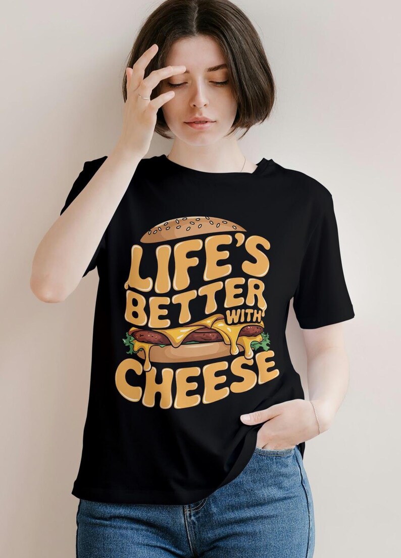 Pu&ograve; includere: Maglietta nera con un'immagine di un cheeseburger e il testo "Life's Better With Cheese".
