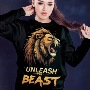 Puede incluir: Sudadera negra con un gr&aacute;fico de un le&oacute;n rugiente y el texto "UNLEASH THE BEAST" en amarillo.