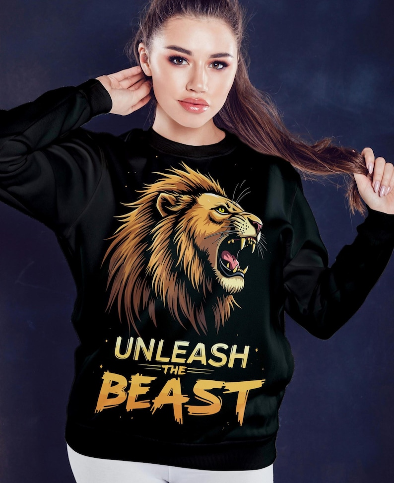 Puede incluir: Sudadera negra con un gr&aacute;fico de un le&oacute;n rugiente y el texto "UNLEASH THE BEAST" en amarillo.