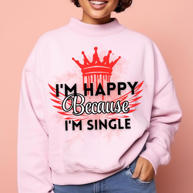 May include: Pink sweatshirt with a graphic print of a crown, wings, and the text "I'm happy because I'm single".