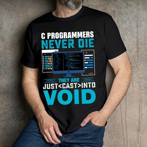 Puede incluir: Camiseta negra con tem&aacute;tica de programaci&oacute;n inform&aacute;tica. La camiseta presenta el texto "C PROGRAMMERS NEVER DIE" en blanco y azul, junto con un gr&aacute;fico de pantalla de ordenador y las palabras "THEY ARE JUST <CAST> INTO VOID."