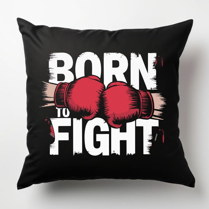 Peut inclure: Un oreiller noir avec du texte blanc qui dit "Born to Fight" et un graphique de deux gants de boxe rouges.