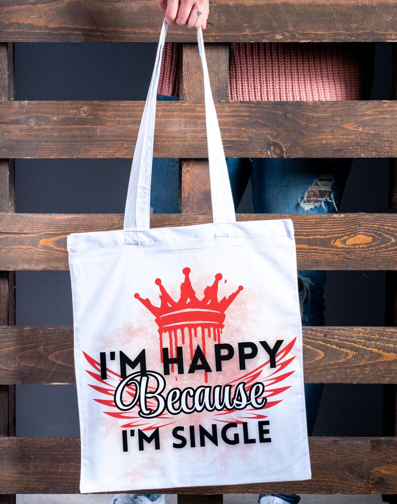 May include: White tote bag with a red crown and the text "I'm Happy Because I'm Single" printed on it.