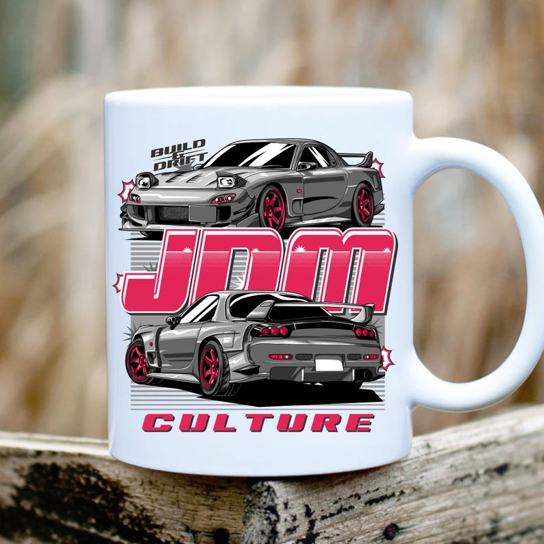 Puede incluir: Taza de cer&aacute;mica blanca con un dise&ntilde;o de coche deportivo gris y ruedas rojas. La taza tiene el texto "BUILD DRIFT", "JDM" y "CULTURE" en rosa. El dise&ntilde;o incluye vistas delantera y trasera del coche.