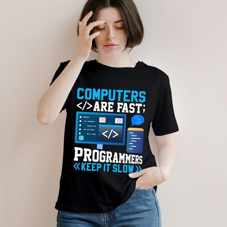 Puede incluir: Camiseta negra con un gr&aacute;fico azul y blanco. El gr&aacute;fico dice "COMPUTERS ARE FAST; PROGRAMMERS KEEP IT SLOW" con s&iacute;mbolos de ordenador y codificaci&oacute;n. La camiseta es de cuello redondo.