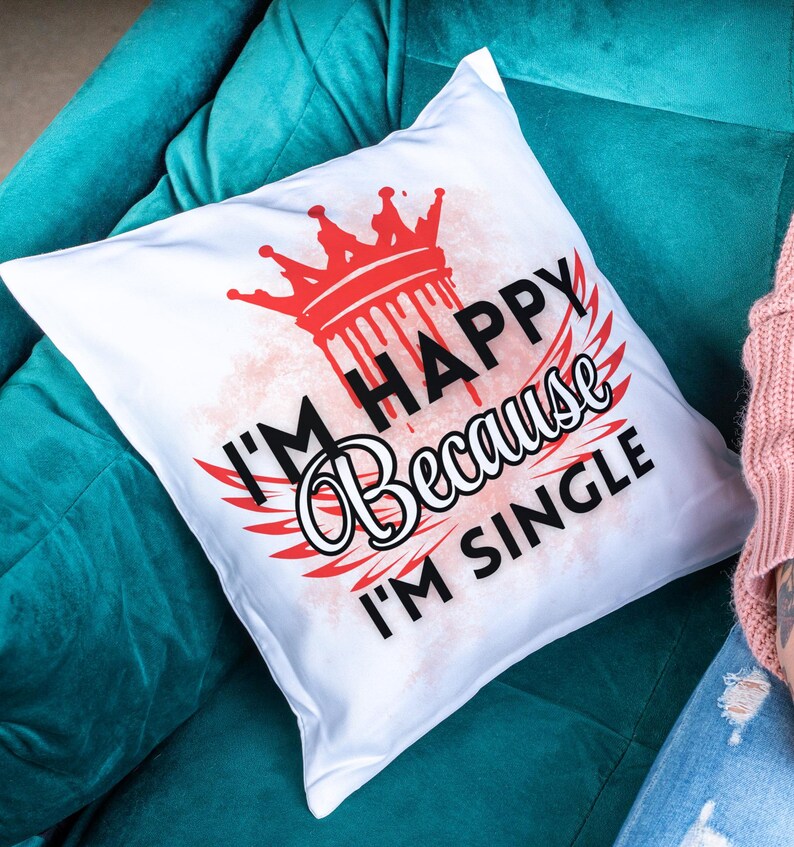 May include: White pillow with a red crown and the text "I'm Happy Because I'm Single" in black.