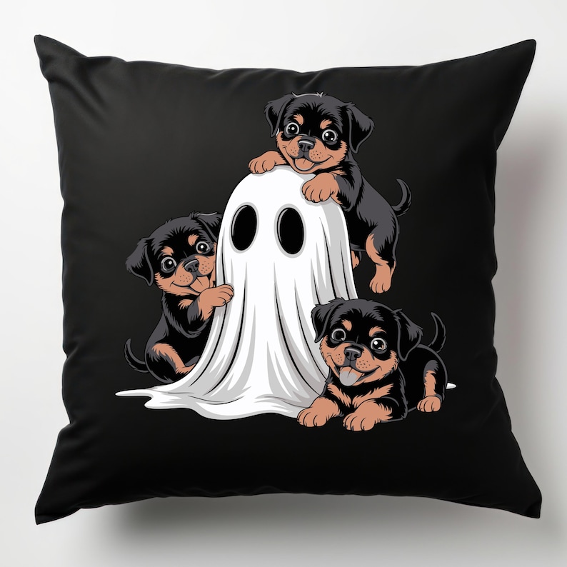 May include: Black throw pillow featuring a Halloween-themed design. Three Rottweiler puppies playfully interact with a white ghost. The puppies have black and brown fur, and the ghost has large, black eye holes. The background is solid black.