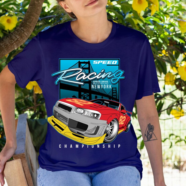 Puede incluir: Camiseta azul marino con un dise&ntilde;o de coche de carreras rojo y gris con el n&uacute;mero 82. El dise&ntilde;o incluye las palabras "SPEED Racing" y "NEWYORK" con una ilustraci&oacute;n de un puente. La palabra "CHAMPIONSHIP" est&aacute; en la parte inferior.