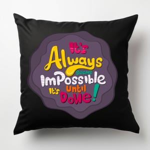 May include: Black throw pillow with a purple circle and the text "It's Always Seems Impossible It's Until Done!" in colorful letters.
