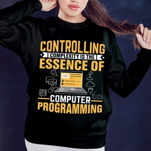 Puede incluir: Sudadera negra con el texto "CONTROLLING COMPLEXITY IS THE ESSENCE OF COMPUTER PROGRAMMING" en amarillo y blanco. El dise&ntilde;o incluye un port&aacute;til, iconos y un s&iacute;mbolo wifi.