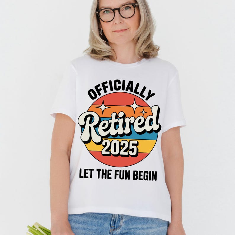 Może przedstawiać: Biała koszulka z kolorową grafiką w stylu retro z napisem "OFFICIALLY Retired 2025". Projekt zawiera tło przypominające zach&oacute;d słońca i słowa "LET THE FUN BEGIN" poniżej. Koszulka jest noszona przez osobę.