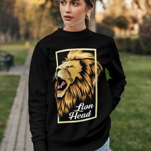Puede incluir: Sudadera negra con un gr&aacute;fico de una cabeza de le&oacute;n en un marco amarillo. El texto "Lion Head" est&aacute; debajo de la imagen.