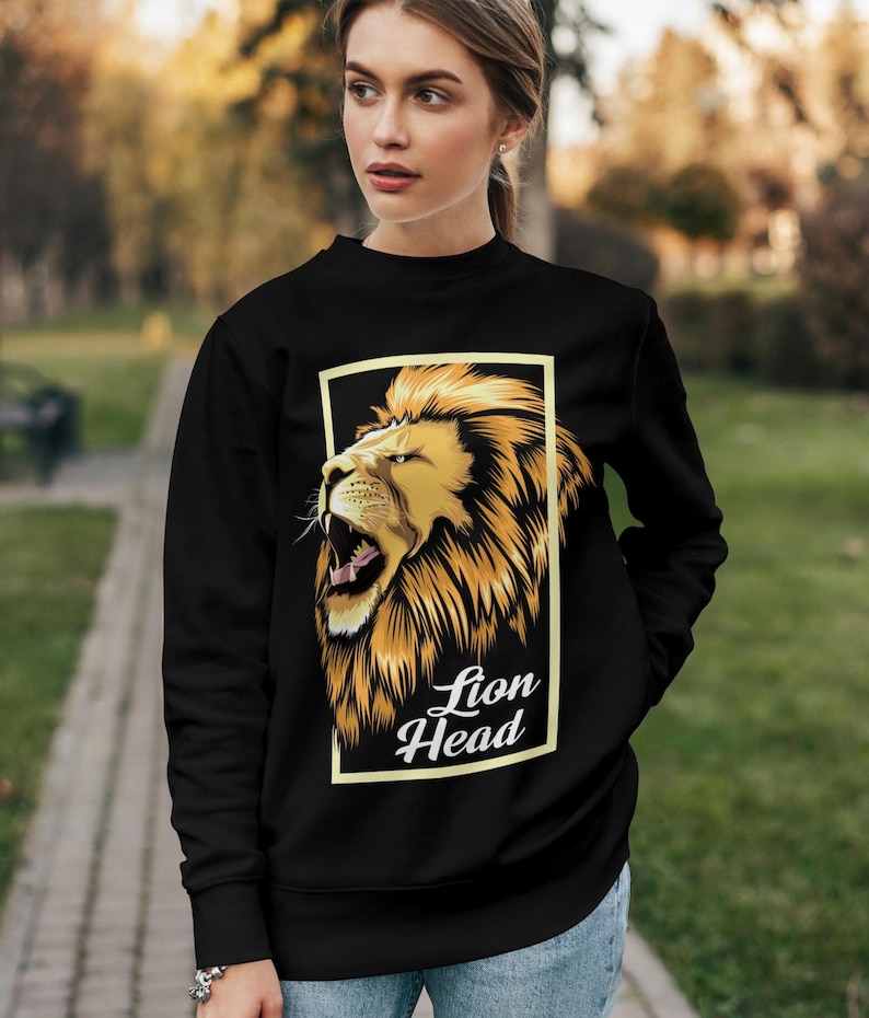 Puede incluir: Sudadera negra con un gr&aacute;fico de una cabeza de le&oacute;n en un marco amarillo. El texto "Lion Head" est&aacute; debajo de la imagen.