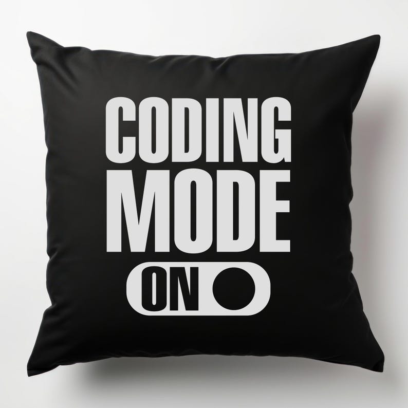 Puede incluir: Coj&iacute;n negro con las palabras "CODING MODE ON" en blanco, en negrita y sin serifa. El texto est&aacute; dispuesto en tres l&iacute;neas, con "ON" como un gr&aacute;fico de interruptor.