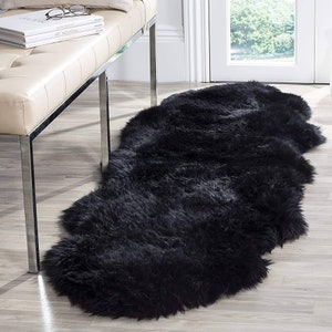 Peut inclure: Un tapis en fausse fourrure noire de forme longue et étroite. Le tapis est doux et moelleux, et il serait parfait pour ajouter une touche de luxe à n'importe quelle pièce.