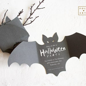 May include: A black bat-shaped invitation with white text that reads "Join us for a Halloween Party" and includes the date, time, and address. The invitation is on a white background with a branch.