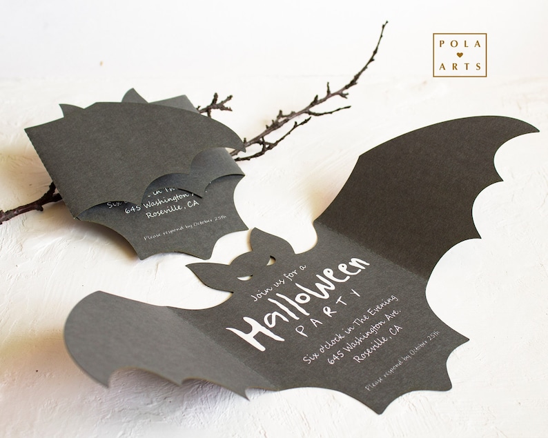 May include: A black bat-shaped invitation for a Halloween party. The invitation is folded in half and has white text that says "Join us for a Halloween Party" and includes the date, time, and address. The invitation is decorated with a small bat cutout.