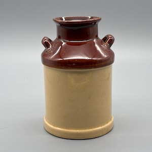 Peut inclure: Pichet à lait en céramique de style vintage, avec un design bicolore. Le dessus et le bord sont marron foncé, tandis que le corps est beige clair. Il possède deux petites anses et une base arrondie, idéal pour la décoration rustique.