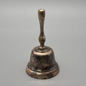 Vintage silverpläterad handklocka med svarvat handtag och naturligt åldrad patina