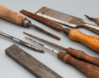Lote de herramientas manuales antiguas: cinceles para madera, limas, gubias y piedra de afilar. Colección de herramientas rústicas de granja.
