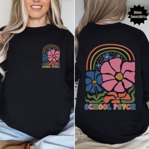 May include: Black sweatshirt with a rainbow and flower design and the text "SCHOOL PSYCH" on the front and back.
