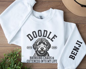 May include: White sweatshirt with a doodle dog graphic and the text "Doodle Est. 2025 Bringing Chaos & Cuteness into My Life" on the front. The sleeve has the name "Benji" printed on it.