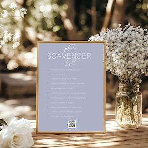 Puede incluir: Un letrero enmarcado con un fondo lila claro y borde dorado, con las palabras "photo scavenger hunt" en escritura cursiva. El letrero enumera indicaciones fotográficas y tiene un código QR en la parte inferior.