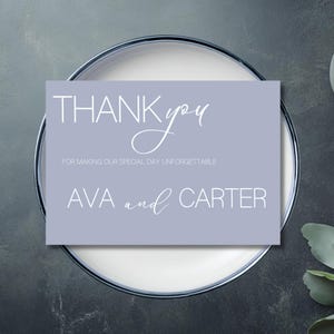 Puede incluir: Una tarjeta de agradecimiento de color lila claro con texto blanco. La tarjeta dice "THANK you", seguido de "FOR MAKING OUR SPECIAL DAY UNFORGETTABLE" y los nombres "AVA and CARTER". La tarjeta está sobre un plato blanco.
