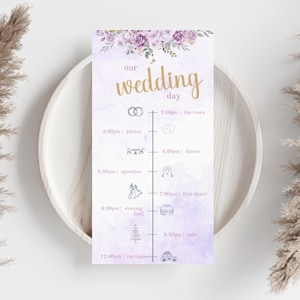 May include: A wedding day schedule card with a purple watercolour background. The card features gold text reading "our wedding day" and includes a timeline with illustrations for the ceremony, dinner, and cake.