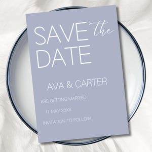 May include: A light purple "Save the Date" card with white text. The card includes the names "AVA & CARTER", the date "17 MAY 20XX", and the phrase "INVITATION TO FOLLOW". The card is on a white plate with a blue rim.