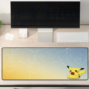 May include: A yellow and blue mouse mat with a cartoon Pikachu character on a yellow background. The mouse mat is on a wooden desk with a computer monitor, keyboard, and mouse.