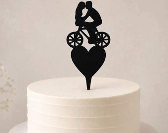 Minimalist wedding cake topper with a bride and groom on a bike