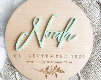 Circular frame with the baby's name and birth details.