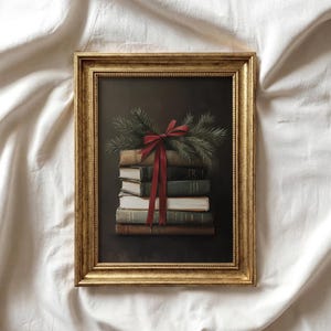 Peut inclure: Une impression d'art encadrée représentant une pile de cinq livres anciens attachés par un ruban rouge et surmontés de branches de pin vertes. L'œuvre est insérée dans un cadre doré orné et texturé sur un fond sombre et nuancé.